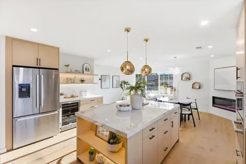 a kitchen with stainless steel appliances granite countertop a sink a stove and a refrigerator