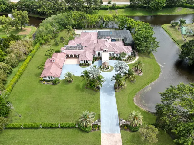 an aerial view of a house with a garden and lake view