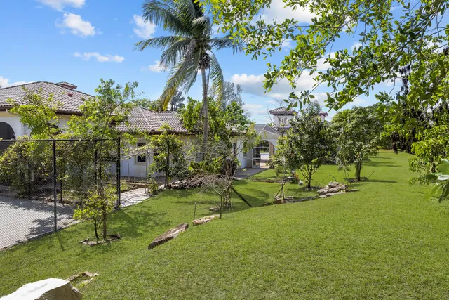 a kitchen with stainless steel appliances a sink a stove a refrigerator a dining table and chairs