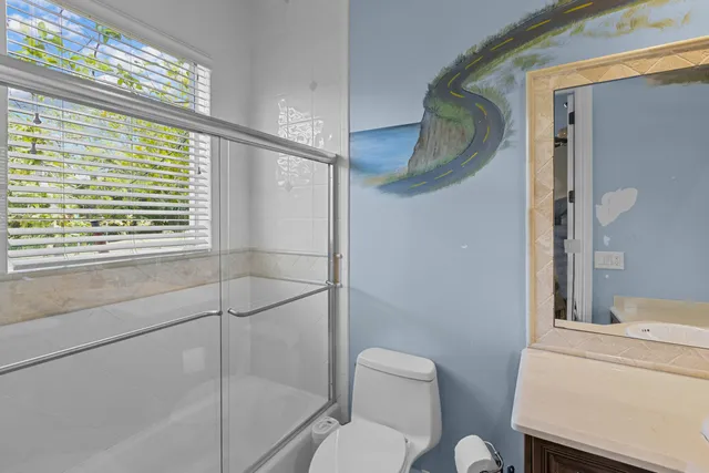 a bathroom with a granite countertop sink toilet and a mirror
