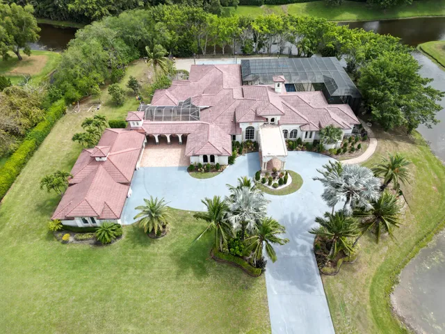 a living room with couches chairs and a large mirror with wooden floor