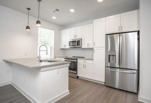 a kitchen with stainless steel appliances a refrigerator sink and microwave