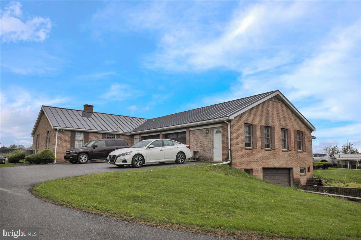 154 West Maple Grove Road Denver, PA 17517 - Photo 5 of 59 a front view of a house with a garden and parking