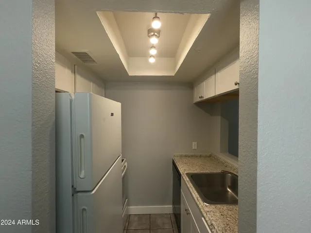 a kitchen with a refrigerator and a stove top oven