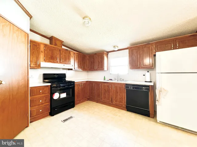 a kitchen with a refrigerator and a stove top oven