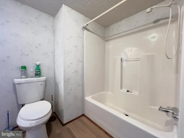 a white toilet sitting next to a bath tub