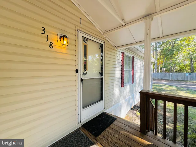 a view of a porch with wooden floor and furniture