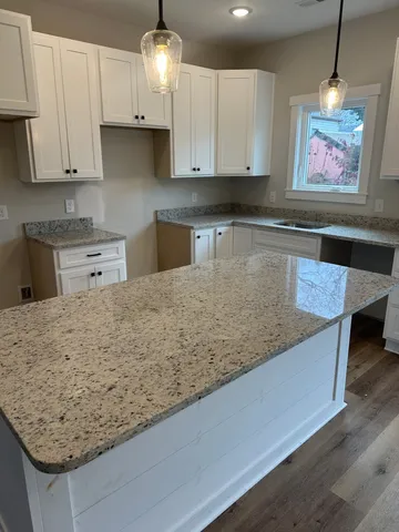 a kitchen with stainless steel appliances granite countertop a sink a stove and a wooden cabinets