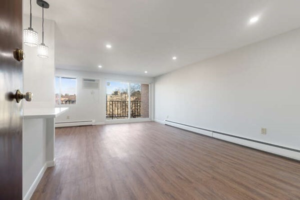 64 Main Street, Unit 53B Stoneham, MA 02180 - Photo 13 of 36 an empty room with wooden floor and windows