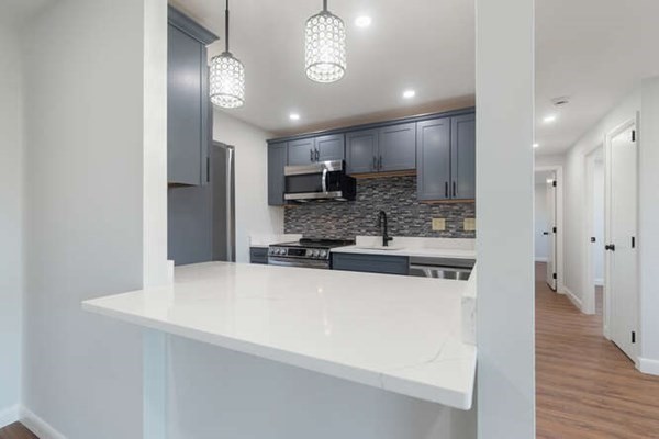 64 Main Street, Unit 53B Stoneham, MA 02180 - Photo 19 of 36 a large kitchen with a large counter top space stainless steel appliances and cabinets