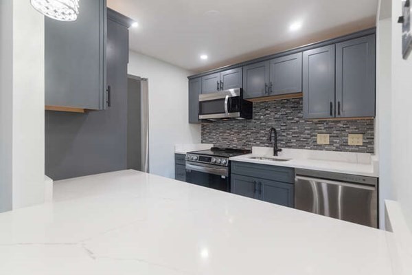 64 Main Street, Unit 53B Stoneham, MA 02180 - Photo 20 of 36 a kitchen with stainless steel appliances kitchen island granite countertop a stove sink and cabinets