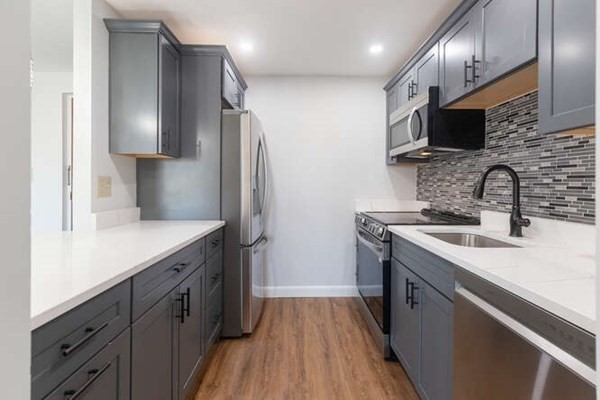 64 Main Street, Unit 53B Stoneham, MA 02180 - Photo 21 of 36 a kitchen with stainless steel appliances a sink dishwasher a refrigerator and a stove with wooden floor