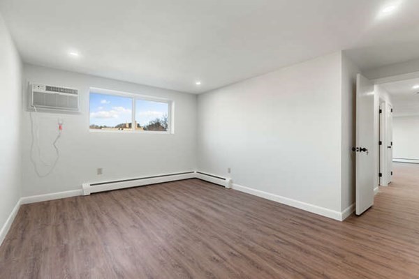 64 Main Street, Unit 53B Stoneham, MA 02180 - Photo 29 of 36 an empty room with wooden floor and windows