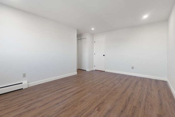 64 Main Street, Unit 53B Stoneham, MA 02180 - Photo 31 of 36 a view of an empty room with wooden floor