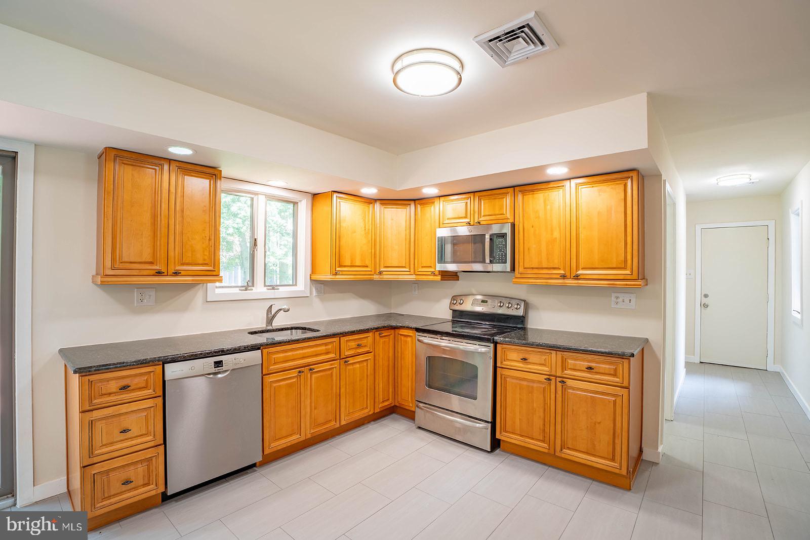 491 Kings Road Yardley, PA 19067 - Photo 16 of 52 a kitchen with stainless steel appliances granite countertop a stove sink and cabinets