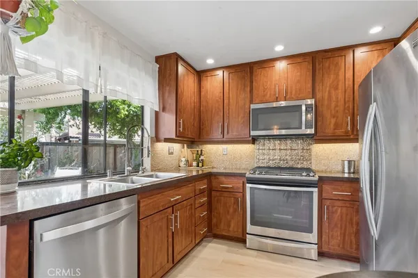 a kitchen with stainless steel appliances granite countertop a sink stove and refrigerator