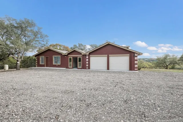 a view of a house with a yard and large tree