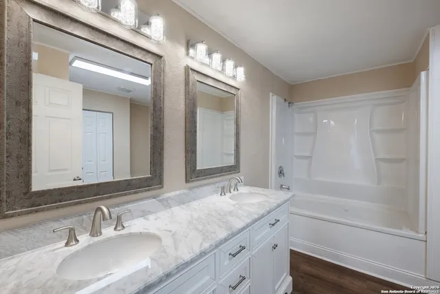 a bathroom with a granite countertop sink a toilet and a mirror