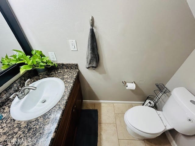 7304 Exeter Street, Unit E Paramount, CA 90723 - Photo 11 of 36 Convenient 1/4 bath located adjacent to the living room, featuring cabinetry that matches the kitchen, granite countertops, and tile flooring.