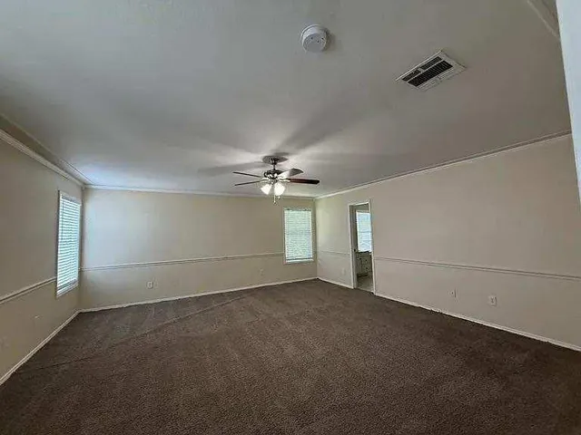 en empty room with windows and ceiling fan view