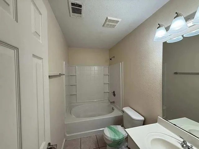 a bathroom with a granite countertop toilet a sink and bathtub