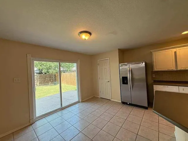 a view of a refrigerator in kitchen and a window