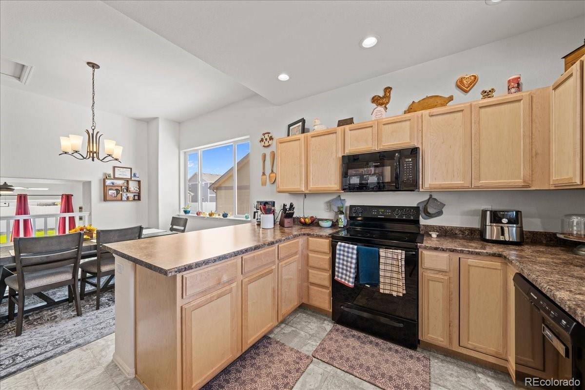949 Ashbrook Drive Windsor, CO 80550 - Photo 12 of 33 a kitchen with stainless steel appliances granite countertop a sink a stove top oven a chimney and a center island