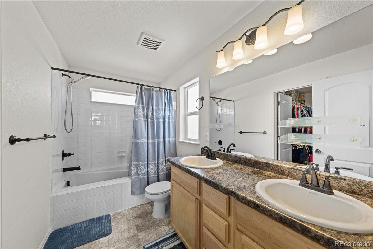 949 Ashbrook Drive Windsor, CO 80550 - Photo 23 of 33 a bathroom with a granite countertop double vanity sink a toilet a mirror and bathtub