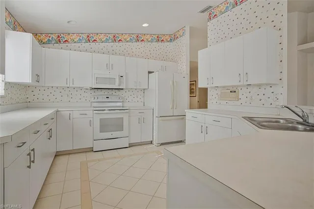 a kitchen with white cabinets and white appliances