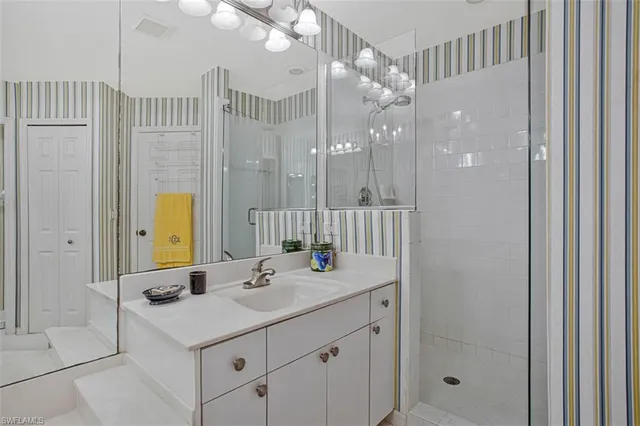 a bathroom with a sink a shower and a mirror