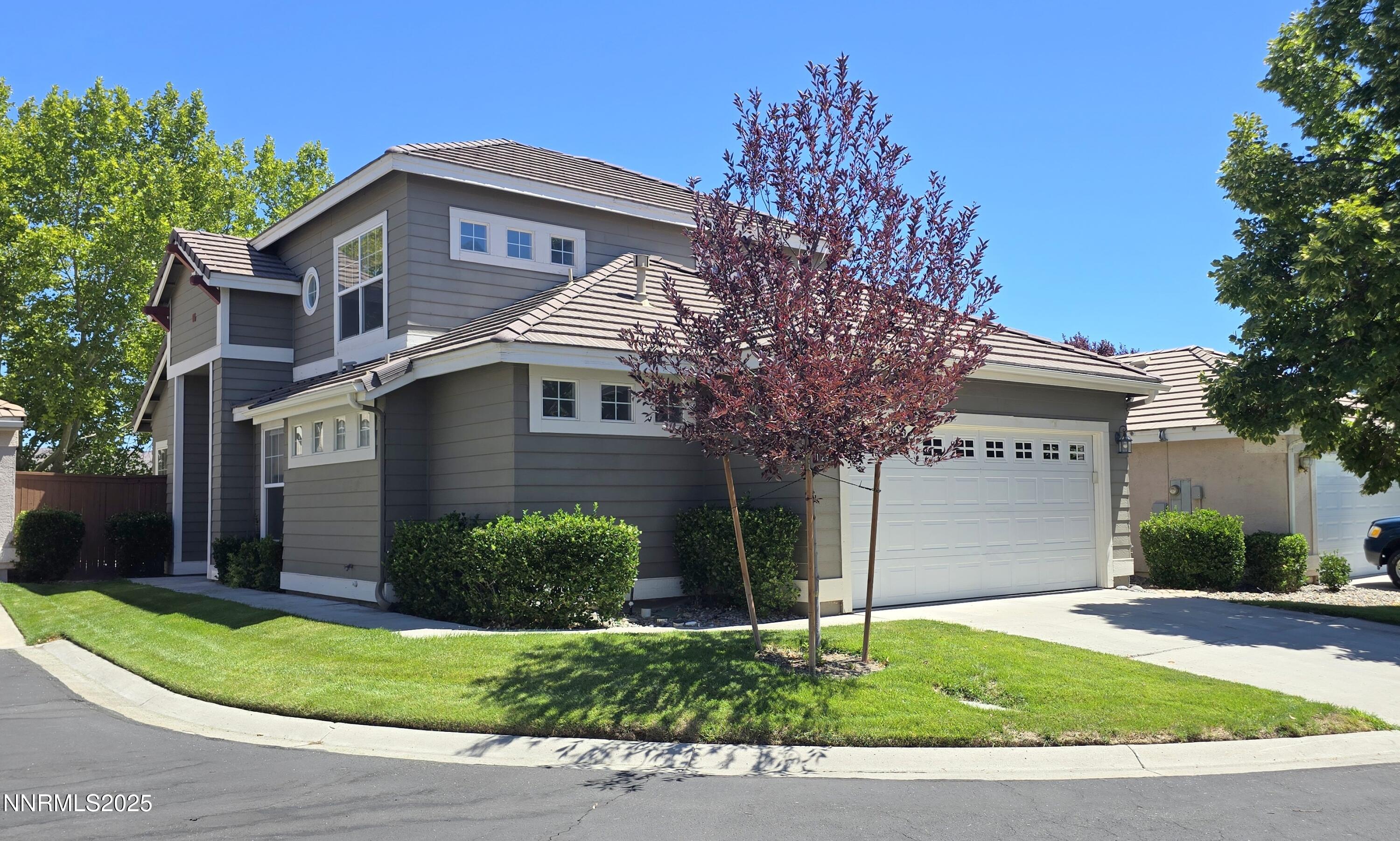 1295 Tule Drive Reno, NV 89521 - Photo 1 of 45 a front view of a house with a yard and garage