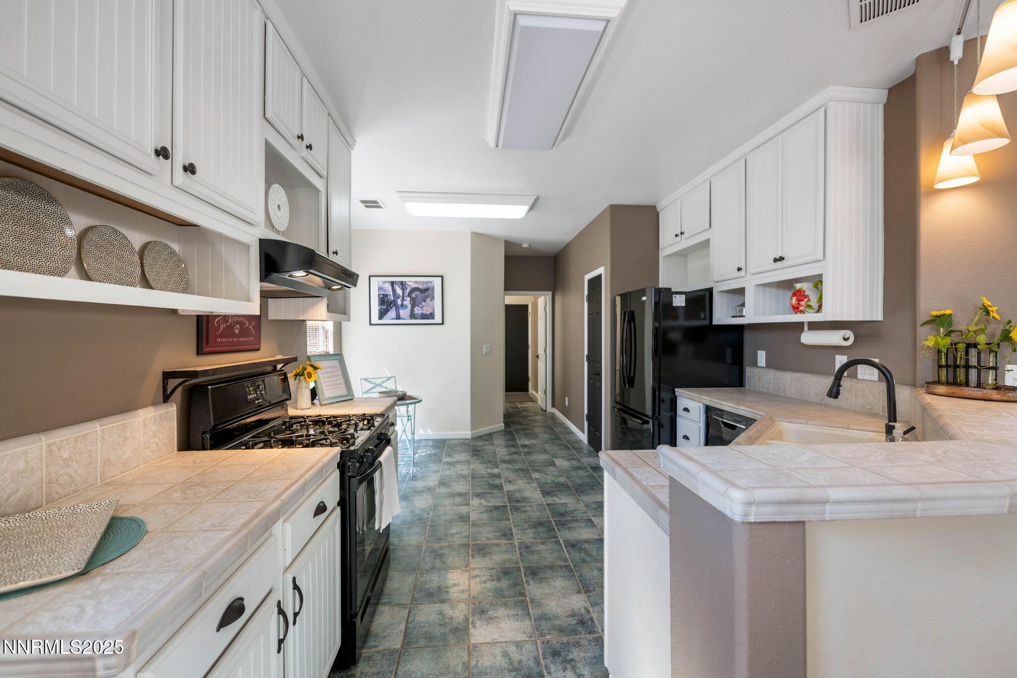1295 Tule Drive Reno, NV 89521 - Photo 8 of 45 a kitchen with stainless steel appliances granite countertop a sink a stove and a refrigerator with white cabinets
