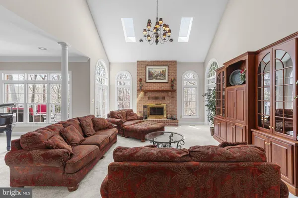 a view of a dining room and livingroom with furniture wooden floor a chandelier