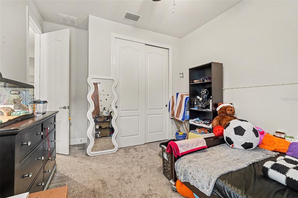 12593 Palapa Loop Spring Hill, FL 34610 - Photo 11 of 21 a bedroom with two beds and a bed