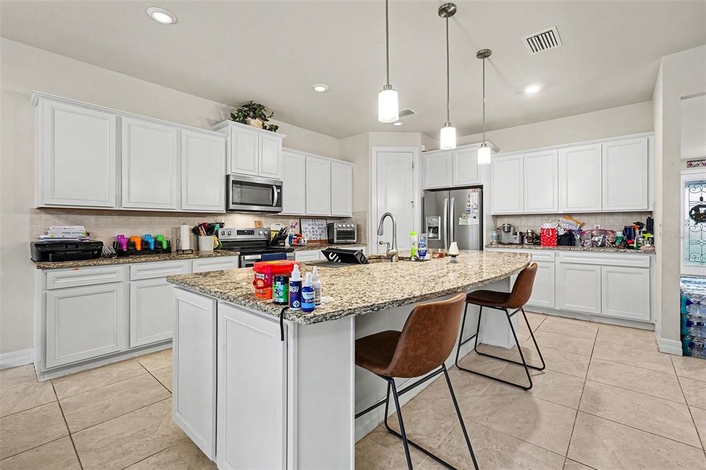 12593 Palapa Loop Spring Hill, FL 34610 - Photo 7 of 21 a kitchen that has a lot of cabinets and refrigerator in it