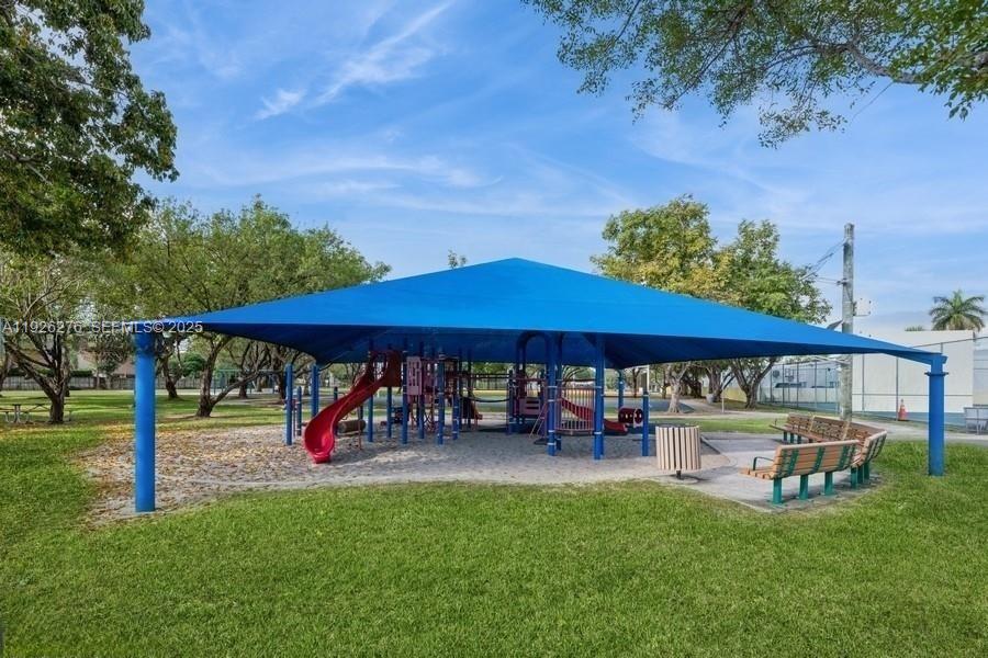 7250 Southwest 94th Place, Unit B6 Miami, FL 33173 - Photo 14 of 23 a view of a patio with a table and chairs under an umbrella
