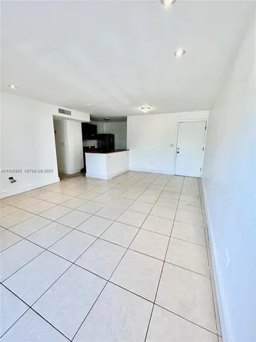 a view of a room with a rug and white walls