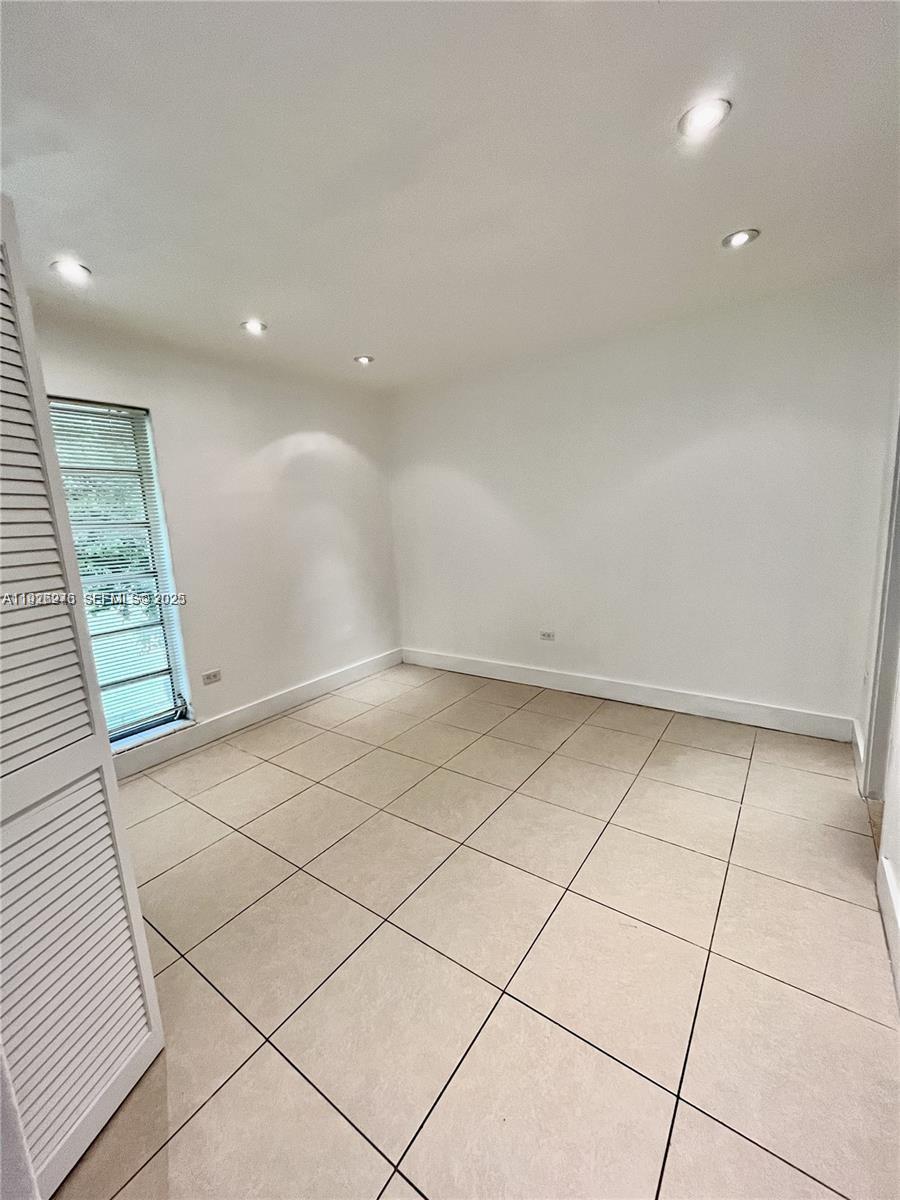 7250 Southwest 94th Place, Unit B6 Miami, FL 33173 - Photo 9 of 23 an empty room with white walls and tiles