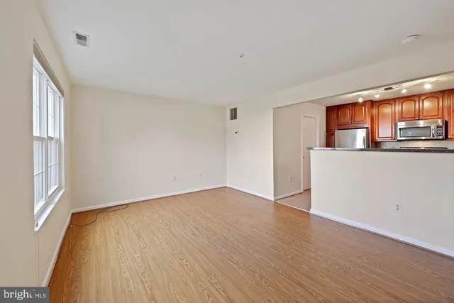 a view of a kitchen with wooden floor and a window