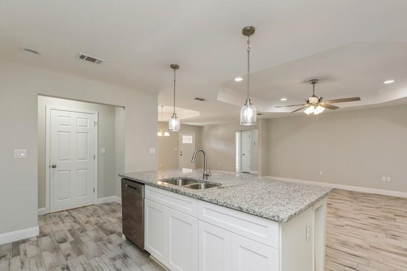 3933 Poverty Creek Road Crestview, FL 32539 - Photo 8 of 32 a view of a kitchen with a sink dishwasher a refrigerator and wooden floor