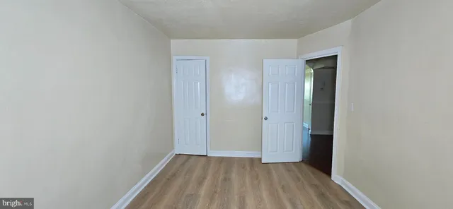 a view of hallway with closet and wooden floor