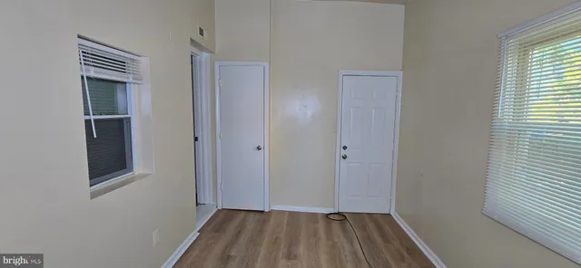 a view of a hallway with wooden floor and a window