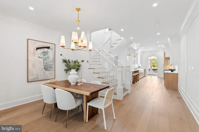 a dining room with furniture a chandelier and wooden floor