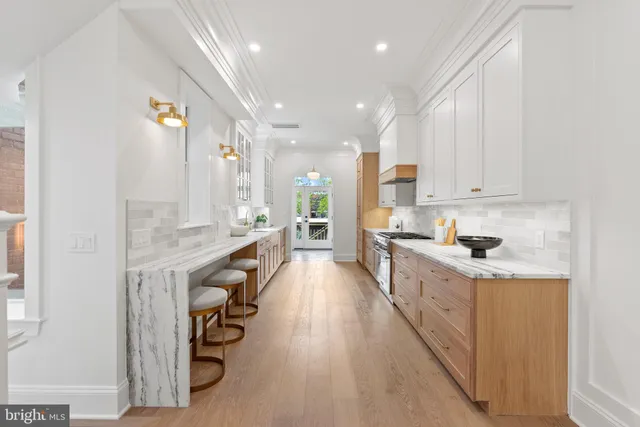 a large kitchen with kitchen island a sink a stove and a wooden floors