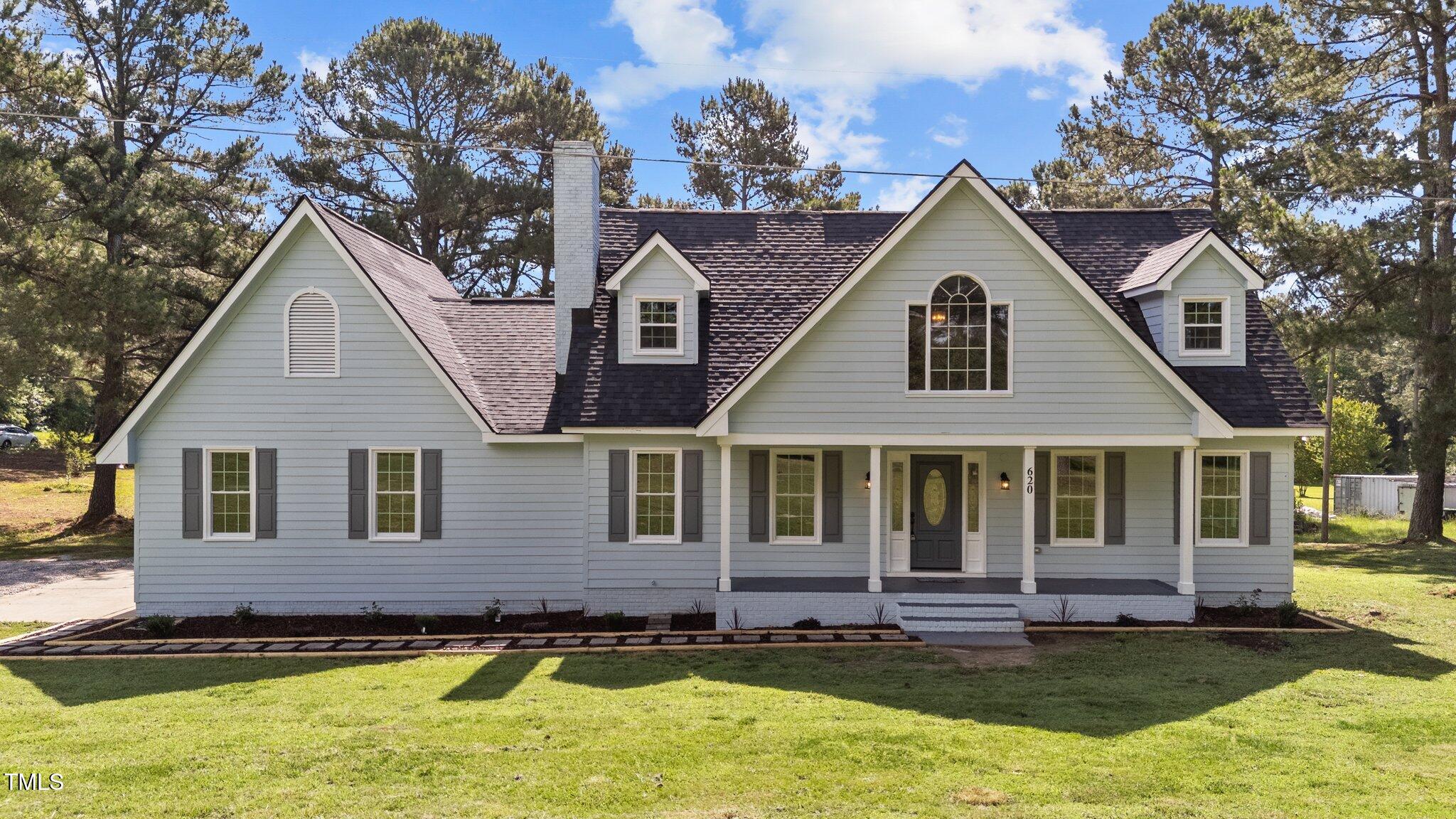 a view of a yard in front of a house with large windows