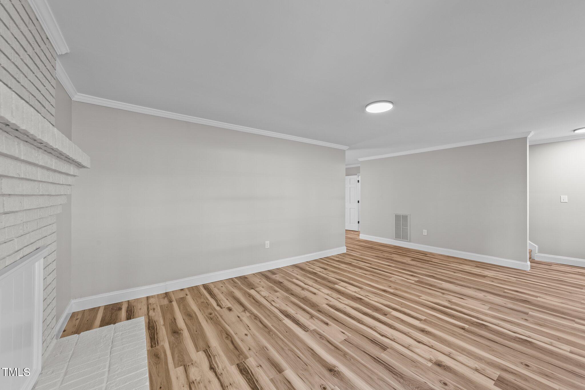 620 Richardson Road Zebulon, NC 27597 - Photo 14 of 52 a view of an empty room with wooden floor