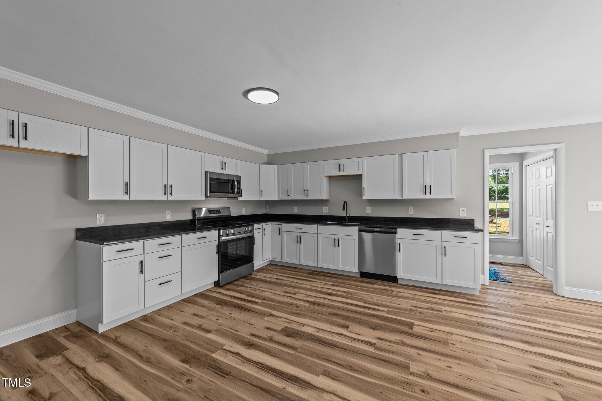 620 Richardson Road Zebulon, NC 27597 - Photo 15 of 52 a large kitchen with stainless steel appliances granite countertop a stove and a sink