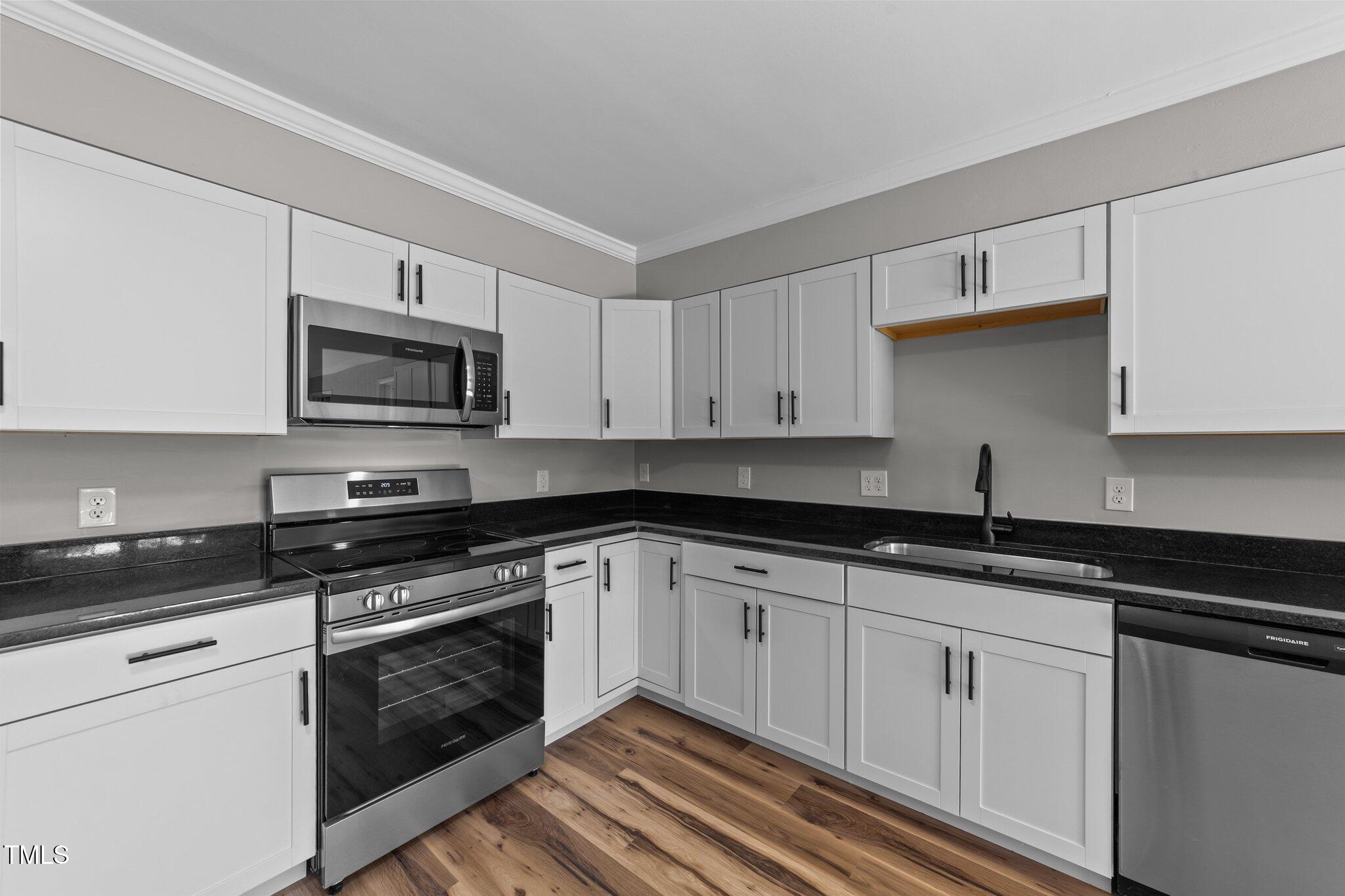 620 Richardson Road Zebulon, NC 27597 - Photo 16 of 52 a kitchen with granite countertop white cabinets stainless steel appliances and a sink