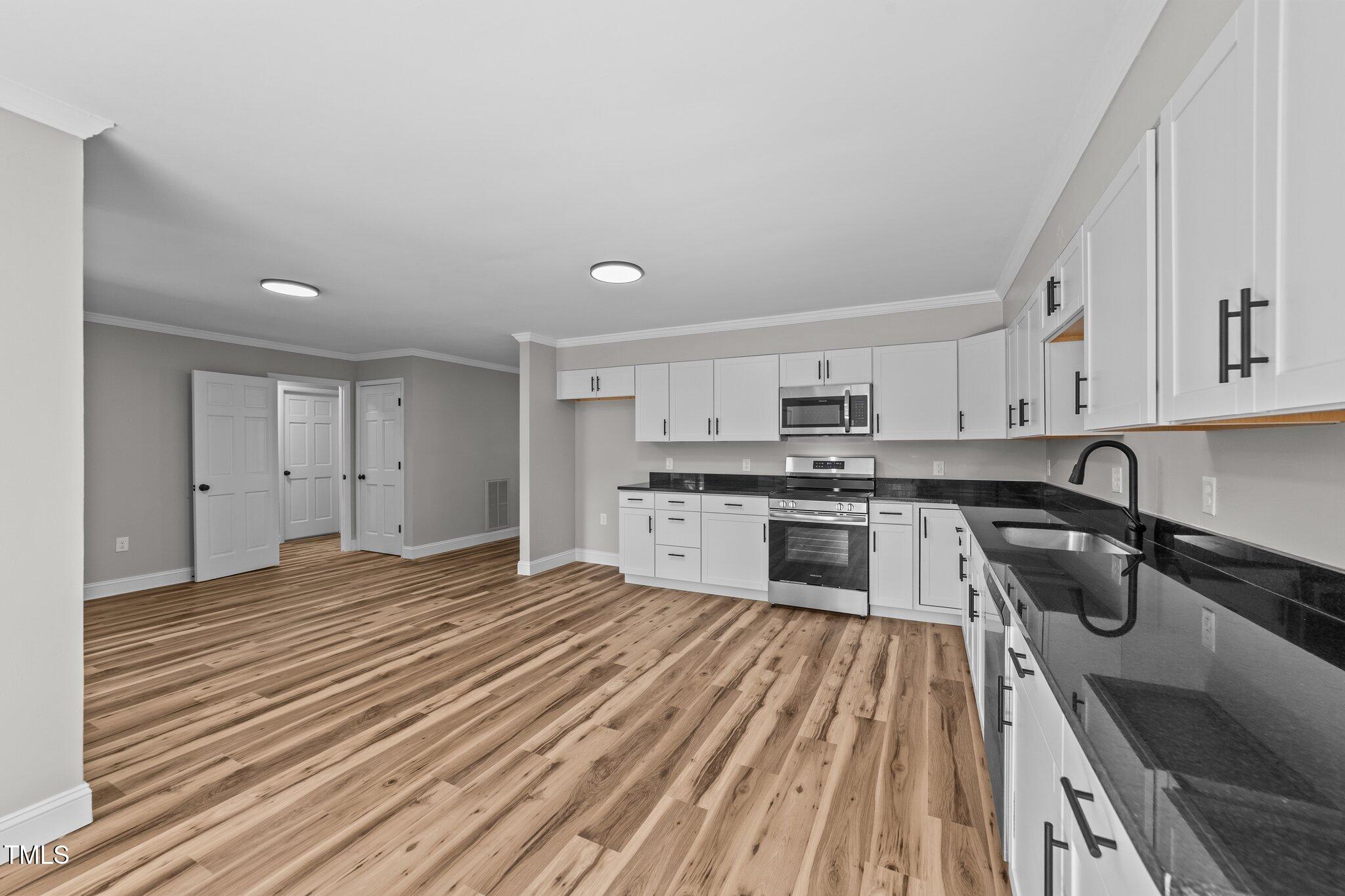 620 Richardson Road Zebulon, NC 27597 - Photo 19 of 52 a kitchen with granite countertop a sink cabinets and stainless steel appliances