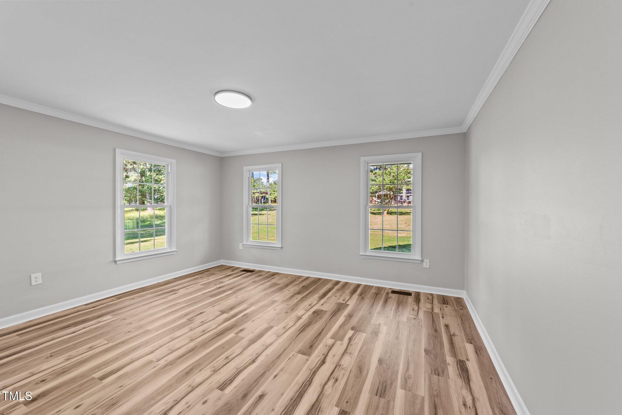 620 Richardson Road Zebulon, NC 27597 - Photo 28 of 52 an empty room with wooden floor and windows